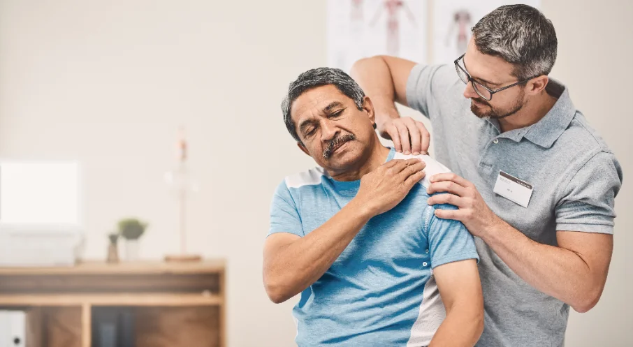 Doctor examining an older patient's shoulder to diagnose the cause of pain