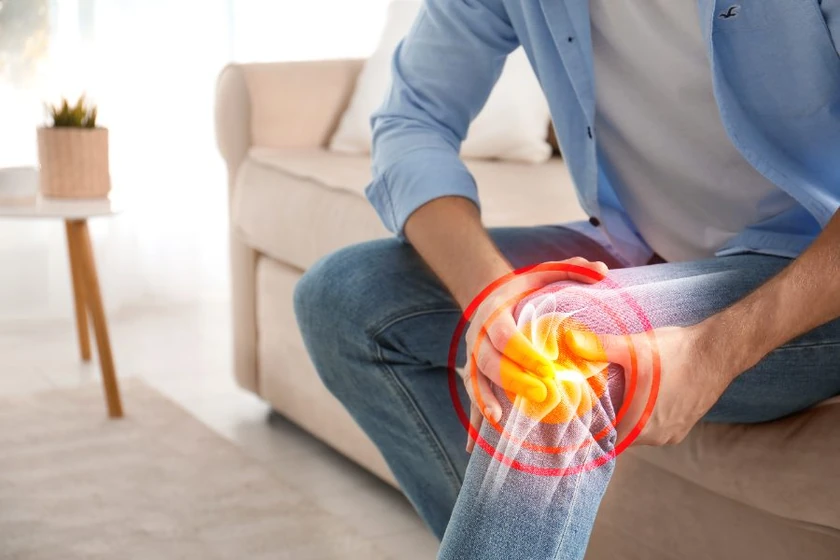 Man holding his knee with the joint highlighted, showing pain from loose fragments inside the knee
