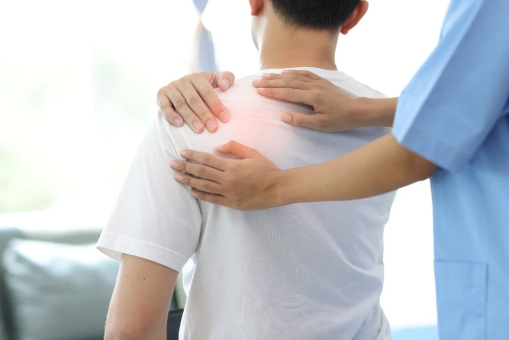 Physiotherapist examining a patient's painful shoulder